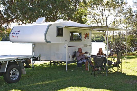 Ozcape Campers Slide-On with people dining under awning at the lake