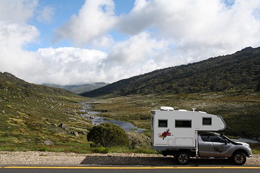 Ozcape Campers Slide-On motorhome Woondabaa parked in front of mountain creek