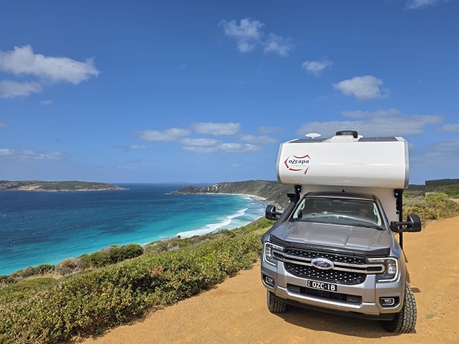 Ozcape Campers Slide-On parked above stunning bay with turquoise waters. Exploring the most beautiful destinations.